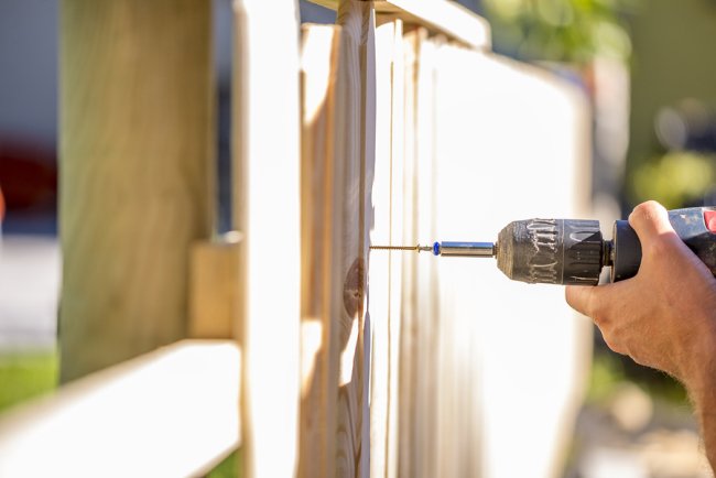 A man is doing hole with a drilling machine