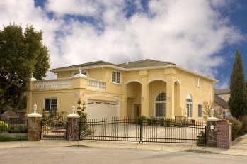 a yellow color house with metal fencing